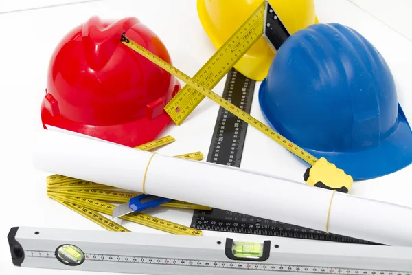 Colorful helmets and tools for construction drawings and buildin — Stock Photo, Image