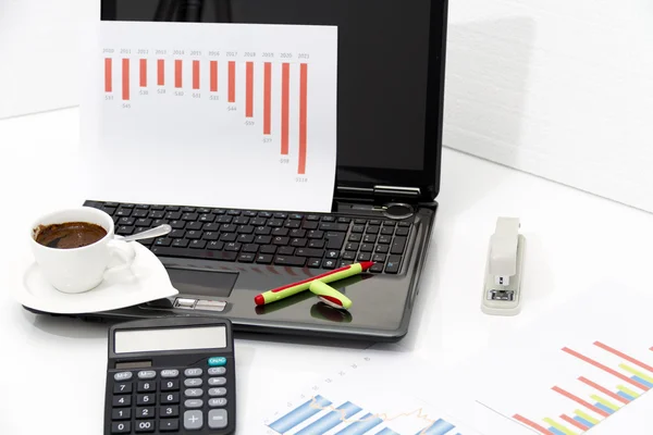 Analyzing business investment charts with calculator and laptop — Stock Photo, Image
