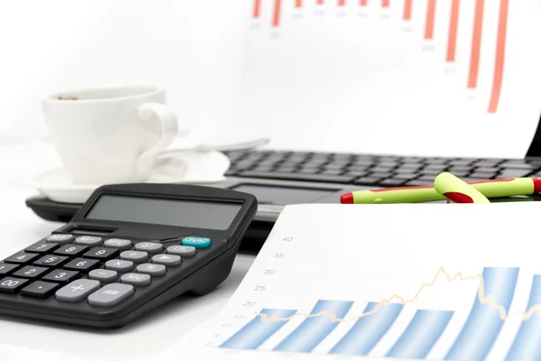 Анализ бизнес-диаграмм с помощью калькулятора и ноутбука — стоковое фото