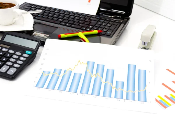 Analyzing business investment charts with calculator and laptop — Stock Photo, Image