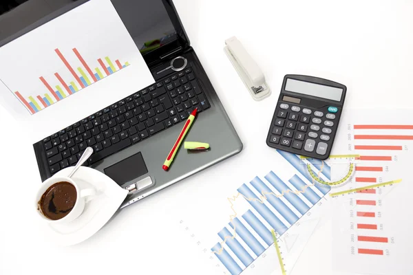 Analyzing business investment charts with calculator and laptop Stock Photo