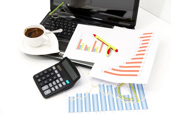 Analyzing business investment charts with calculator and laptop Royalty Free Stock Images