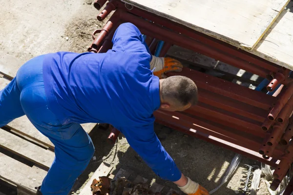 Trabajador trabaja con una pala, limpiando escombros — Foto de Stock