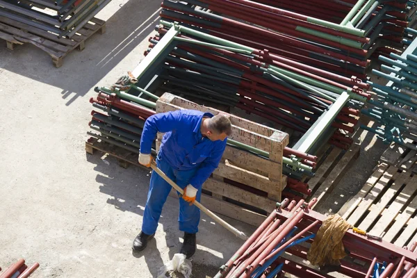 Trabajador trabaja con una pala, limpiando escombros — Foto de Stock