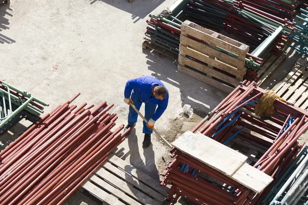 Trabajador trabaja con una pala, limpiando escombros — Foto de Stock