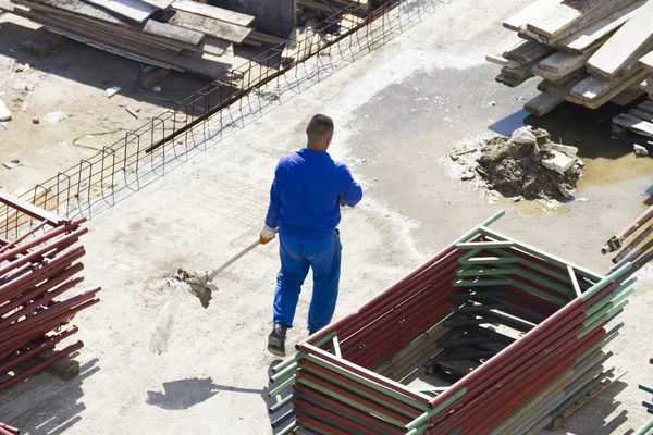 Trabajador trabaja con una pala, limpiando escombros — Foto de Stock