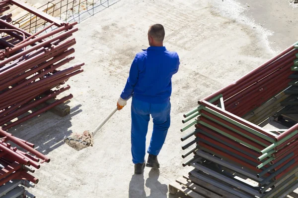 Werknemer werkt met een schop, schoonmaken puin Rechtenvrije Stockfoto's