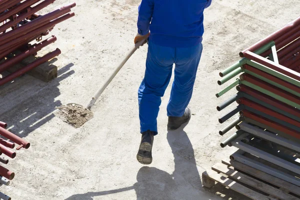 Trabajador trabaja con una pala, limpiando escombros — Foto de Stock