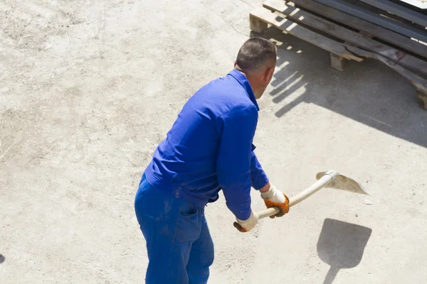 Trabajador trabaja con una pala, limpiando escombros — Foto de Stock