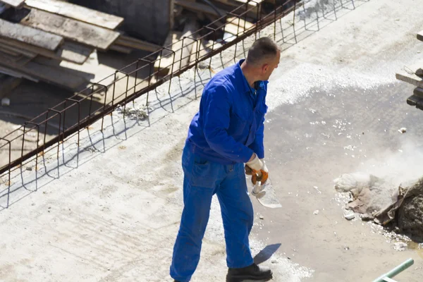 Trabajador trabaja con una pala, limpiando escombros — Foto de Stock