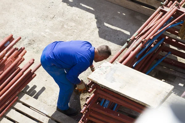 Trabajador trabaja con una pala, limpiando escombros — Foto de Stock