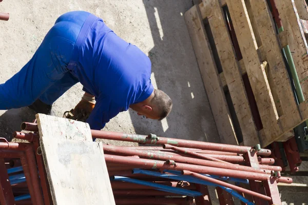 Trabajador trabaja con una pala, limpiando escombros — Foto de Stock