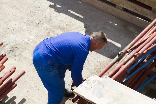 Lavoratore lavora con una pala, pulendo macerie — Foto Stock