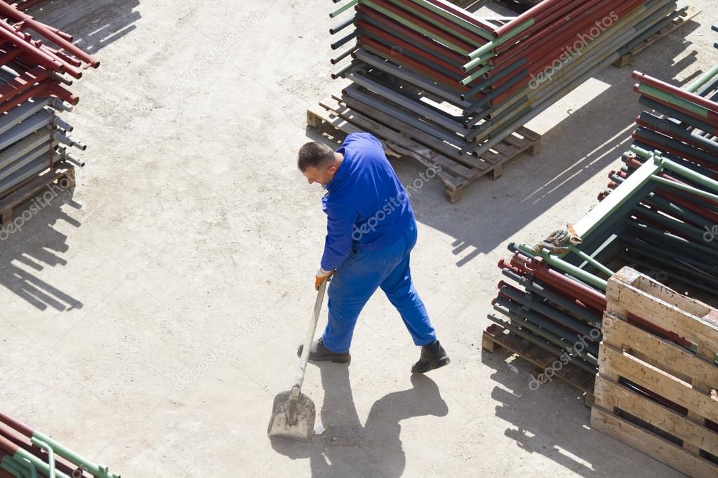 Worker works with a shovel, cleaning rubble