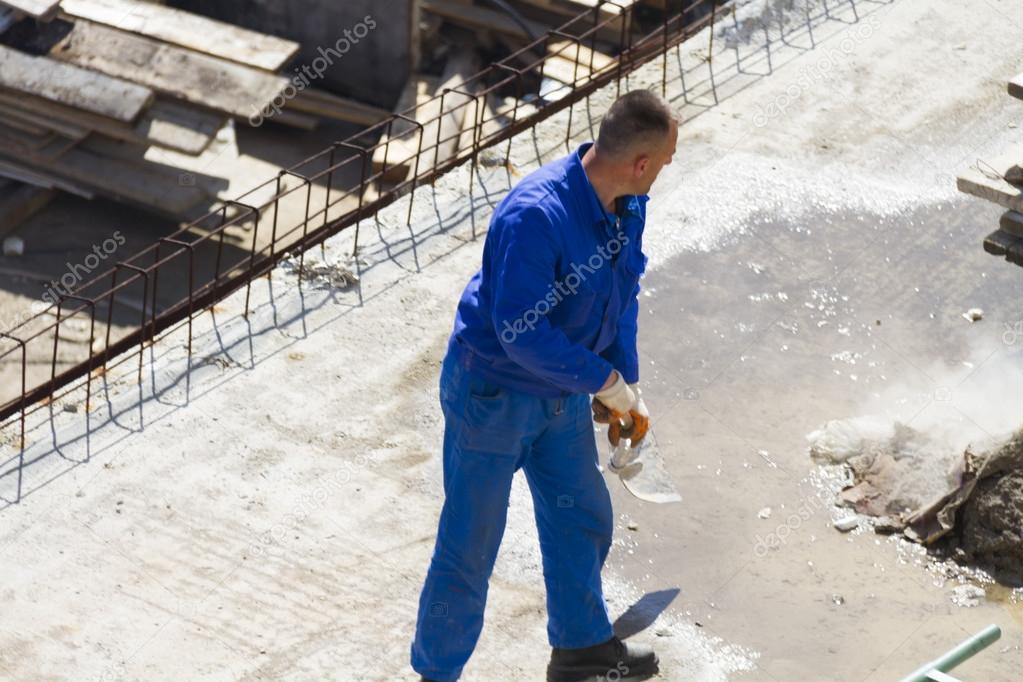 Worker works with a shovel, cleaning rubble