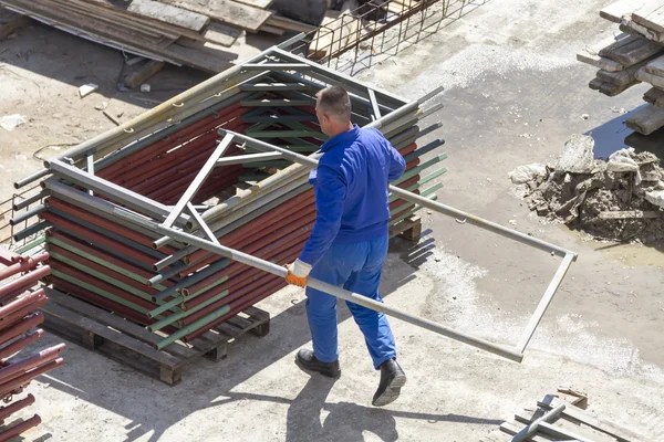 Trabajador trabaja con una pala, limpiando escombros — Foto de Stock