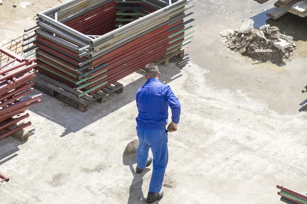 Trabajador trabaja con una pala, limpiando escombros — Foto de Stock