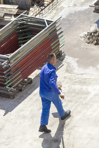 Werknemer werkt met een schop, schoonmaken puin Rechtenvrije Stockafbeeldingen