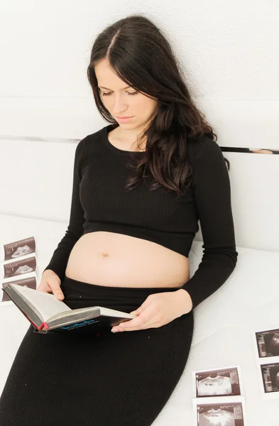 La mujer embarazada disfruta mirando la ecografía del bebé. — Foto de Stock