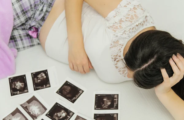 La mujer embarazada disfruta mirando la ecografía del bebé. — Foto de Stock