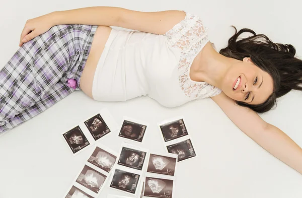 La mujer embarazada disfruta mirando la ecografía del bebé. — Foto de Stock