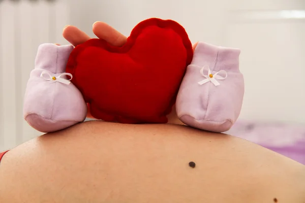 Schwangere mit Babyschuhen — Stockfoto