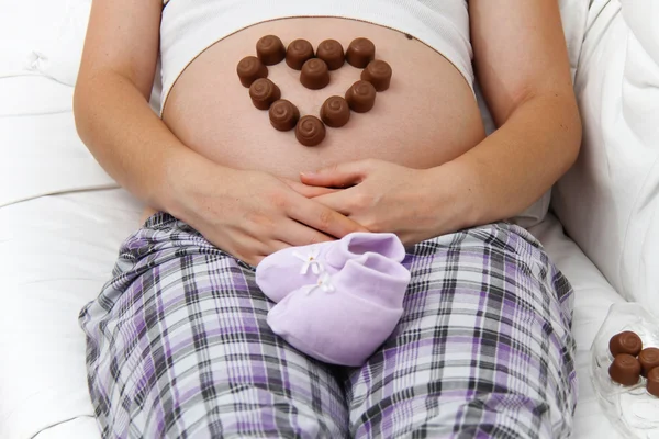 Femme enceinte mangeant du chocolat — Photo