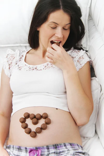 Gravid kvinna äter choklad — Stockfoto
