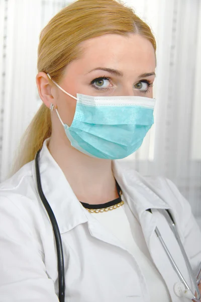 Young female doctor with mask and stethoscope