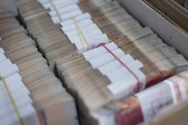 Kutularda depolanan organize banknot yığınlarının kapatılması, zenginlik, finans, tasarruf ve bankacılık işlemleri temsil.