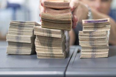 Para sayma makinesinin yanına yerleştirilmiş banknotlar düzgünce istiflenmiş..