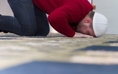 Müslüman adam camide namaz kılıyor.