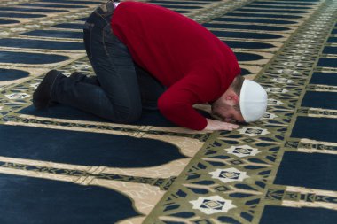 Müslüman adam camide namaz kılıyor.