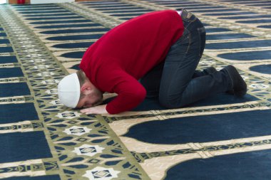 Müslüman adam camide namaz kılıyor.