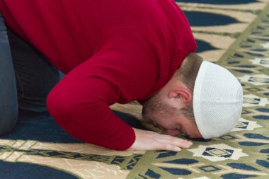 Müslüman adam camide namaz kılıyor.
