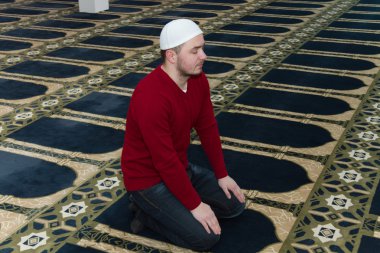 Müslüman adam camide namaz kılıyor.