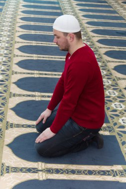 Müslüman adam camide namaz kılıyor.