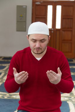 Müslüman adam camide namaz kılıyor.