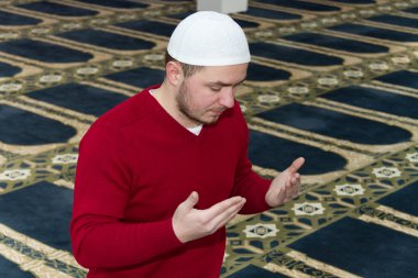 Müslüman adam camide namaz kılıyor.