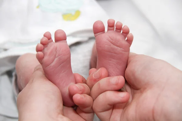 Baby's mond in handen van de moeder, pasgeboren baby beetje benen — Stockfoto