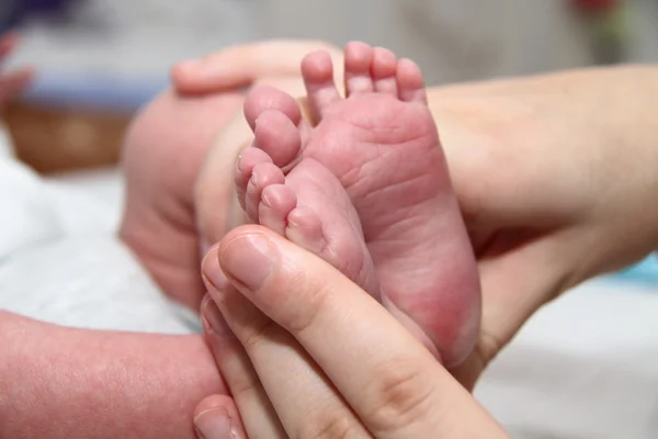 Baby's mond in handen van de moeder, pasgeboren baby beetje benen — Stockfoto