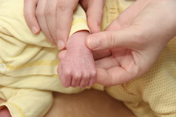 母と彼女の生まれたばかりの赤ちゃんは、新生児の手を保持している親 — ストック写真
