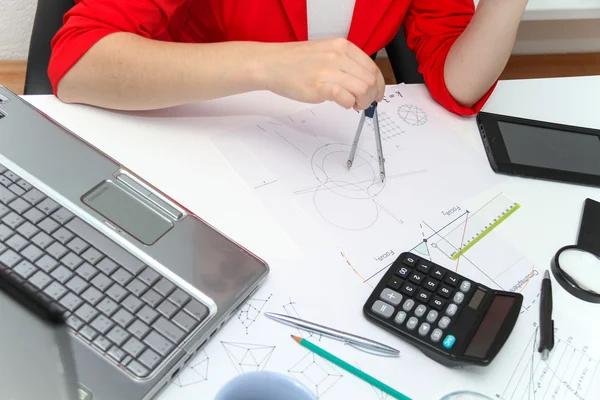 Young female designer working with architectural plan — Stock Photo, Image