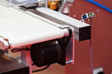 Konveyör bant üstünde belgili tanımlık makine 