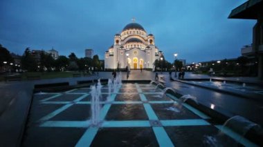 Belgrad, Sırbistan için Aziz Sava Tapınağı geçen insanlar ile yağmurlu gecede çeşme ile.