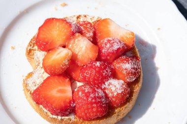 Beyaz tepside şekerli çilekli bir rusks. mavi arka plan. Seçici odak.