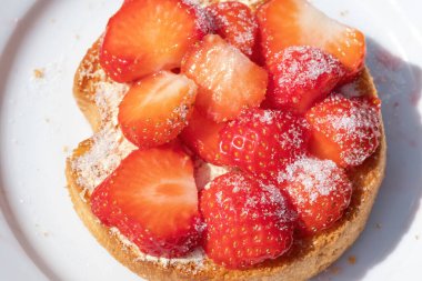 Beyaz tepside şekerli çilekli bir rusks. mavi arka plan. Seçici odak.