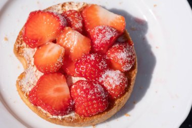 Biri beyaz tepside çilekli ve şekerli rusks. Yukarıdan görülüyor. Seçici odak.