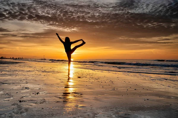 Γιόγκα το ηλιοβασίλεμα στην παραλία. γυναίκα κάνει γιόγκα και απολαμβάνει τη ζωή στη θάλασσα — Φωτογραφία Αρχείου