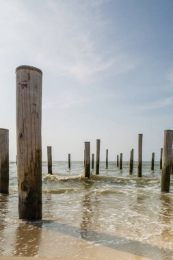 Uzun pozlu deniz manzarası. Petten 'de Kuzey Denizi' nde deniz kenarındaki kutup köyü, mavi gökyüzü, güneş ve ayakkabı ile çekildi. Önplana odaklan